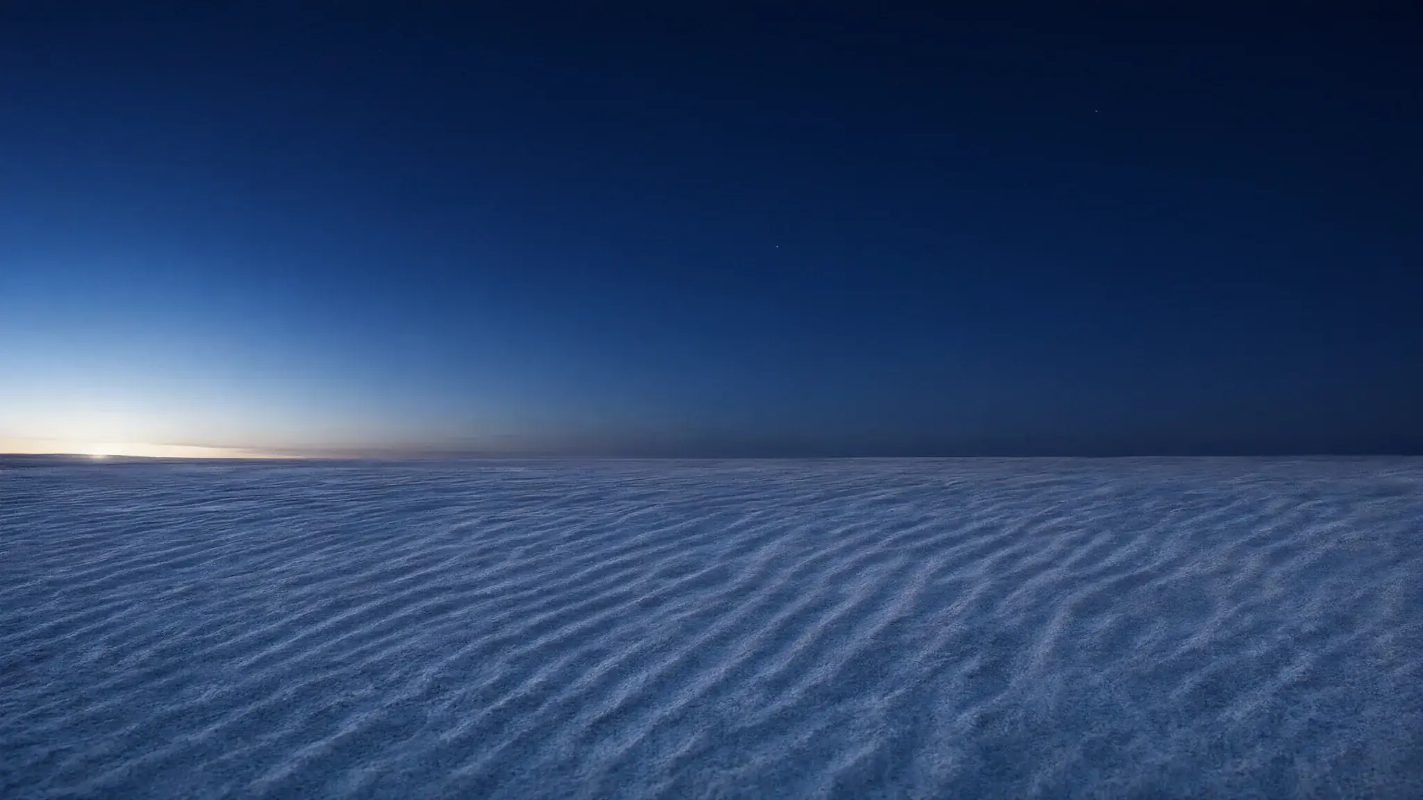 Rippled white sand running flat to the horizon under a pale sky